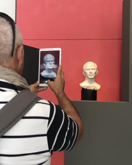 Visiteur du musée en train de photographier le buste présumé de Jules César