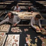 3 archéologues et une retsauratrice travaillent sur le puzzle antique géant 